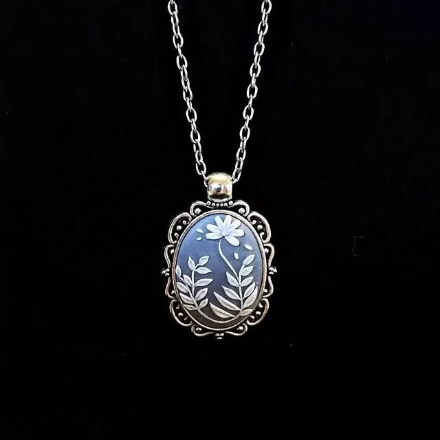 Blue polymer clay cameo pendant with white leaves in a silver frame