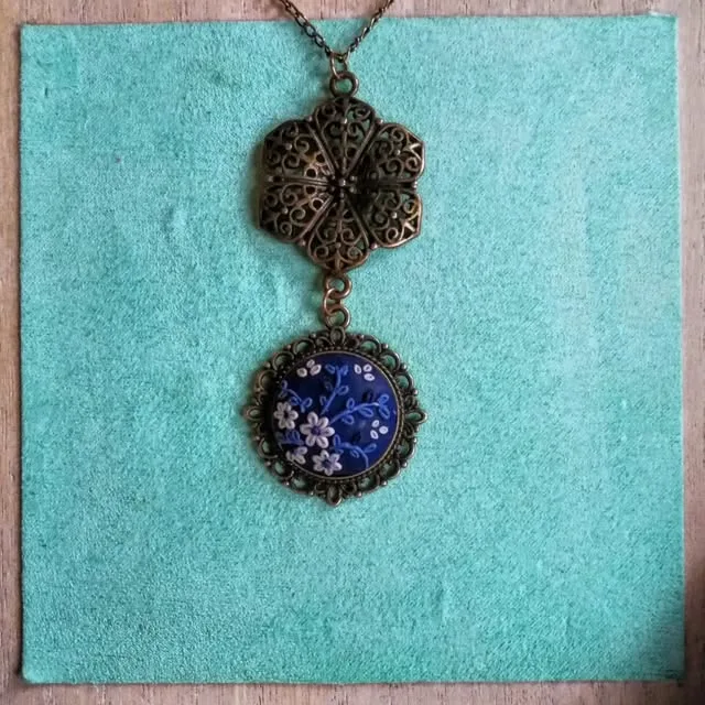 Bronze filigree pendant with a blue floral cabochon
